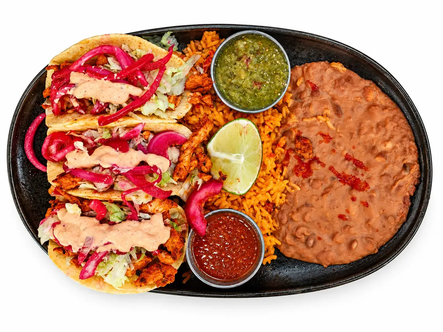Chicken street tacos with lettuce, curtido, and chipotle sauce