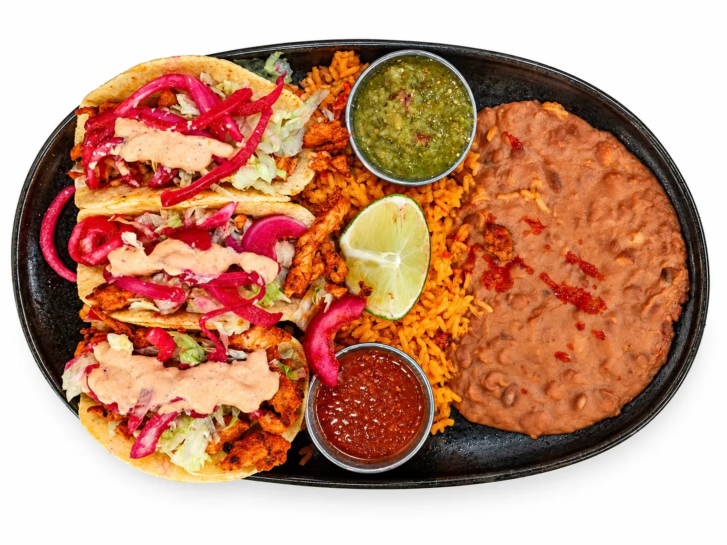Chicken street tacos with lettuce, curtido, and chipotle sauce, served with rice and beans