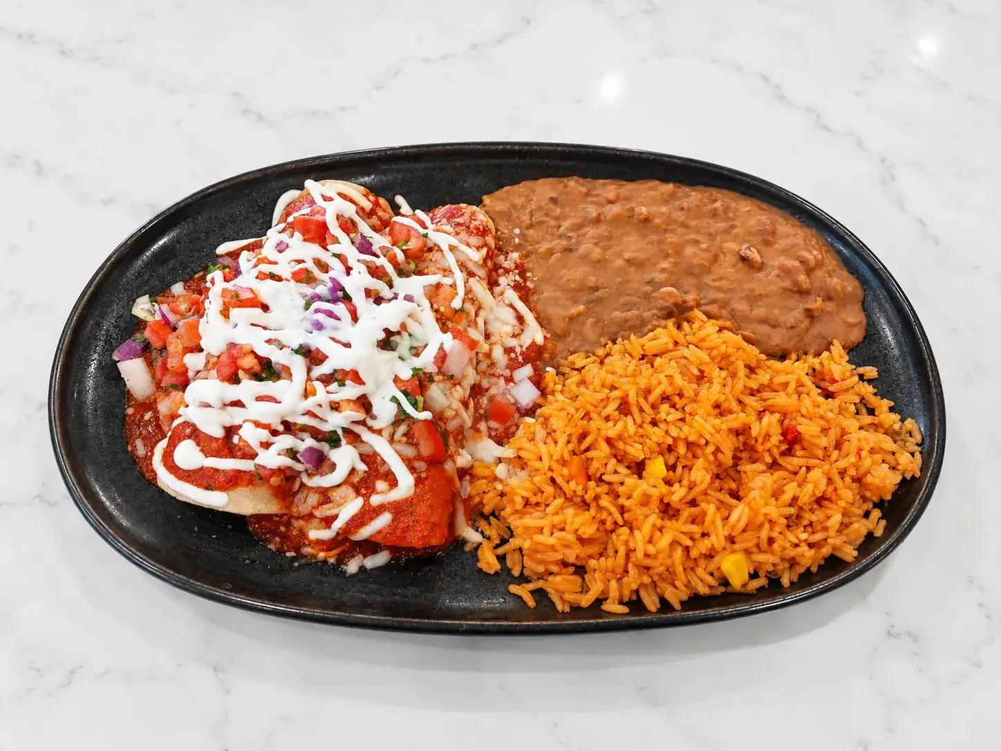 Enchiladas suizas smothered in sauce and melted cheese
